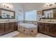 Luxurious bathroom featuring dual vanities and a tiled bathtub, perfect for relaxation at 11224 E Carol Ave, Scottsdale, AZ 85259