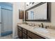 Double sink bathroom with granite countertop, a large mirror, dark wood cabinets and shower with curtain at 11224 E Carol Ave, Scottsdale, AZ 85259