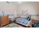 Inviting bedroom with a single bed, playful dinosaur decor, soft lighting, and wooden furnishings at 11224 E Carol Ave, Scottsdale, AZ 85259