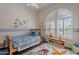 Bright bedroom with a single bed, dinosaur accents, light-filled windows, and a whimsical rug at 11224 E Carol Ave, Scottsdale, AZ 85259