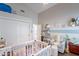 Charming Bedroom featuring a white crib, chair and shelving for toys and books at 11224 E Carol Ave, Scottsdale, AZ 85259