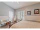 Bright bedroom featuring wood floors, a bed with a wooden frame, shutters, and neutral colored walls at 11224 E Carol Ave, Scottsdale, AZ 85259