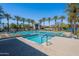 Stunning community pool and hot tub surrounded by lush greenery, palm trees, and plenty of lounge chairs for relaxing at 11224 E Carol Ave, Scottsdale, AZ 85259