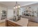 Gourmet kitchen features an island, travertine flooring, stainless appliances, and an open layout to the living room at 11224 E Carol Ave, Scottsdale, AZ 85259