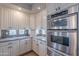 Well-appointed kitchen with white cabinetry, granite counters, mosaic backsplash, and stainless steel appliances at 11224 E Carol Ave, Scottsdale, AZ 85259