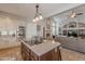 Gourmet kitchen features an island, travertine flooring, stainless appliances, and an open layout to the living room at 11224 E Carol Ave, Scottsdale, AZ 85259