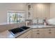 A well lit kitchen sink with a window showcasing the front yard at 11224 E Carol Ave, Scottsdale, AZ 85259