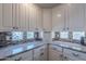Bright kitchen featuring white cabinets, granite countertops, and mosaic tile backsplash at 11224 E Carol Ave, Scottsdale, AZ 85259