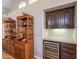Home wet bar with wood cabinetry, granite countertop, and wine fridge at 11224 E Carol Ave, Scottsdale, AZ 85259