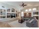 Expansive living room featuring a large sectional sofa, built-in shelving, and a ceiling fan at 11224 E Carol Ave, Scottsdale, AZ 85259