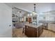 Open-concept living space with kitchen island, travertine flooring, and vaulted ceilings at 11224 E Carol Ave, Scottsdale, AZ 85259