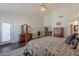 Bright main bedroom with a wooden dresser, ceiling fan, and an ensuite bathroom at 11224 E Carol Ave, Scottsdale, AZ 85259