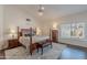 Spacious main bedroom featuring a four-poster bed, hardwood floors, and a ceiling fan at 11224 E Carol Ave, Scottsdale, AZ 85259