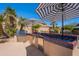 Outdoor kitchen with stainless-steel grill, built-in storage, and vibrant tile countertops at 11224 E Carol Ave, Scottsdale, AZ 85259