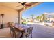 Covered patio with a wooden table, seating, and a view of the landscaped backyard at 11224 E Carol Ave, Scottsdale, AZ 85259