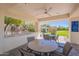 Inviting covered patio featuring a ceiling fan and scenic views of the lush landscaped backyard and charming gazebo at 11224 E Carol Ave, Scottsdale, AZ 85259