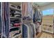Organized walk-in closet with ample shelving and hanging space, illuminated by a window at 11224 E Carol Ave, Scottsdale, AZ 85259