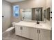Well-lit bathroom with a large mirror, white cabinets, and modern fixtures at 11663 W Luxton Ln, Avondale, AZ 85323