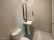 Powder room featuring a pedestal sink, toilet and simple, modern design at 11663 W Luxton Ln, Avondale, AZ 85323