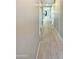 Long hallway featuring tile floors, neutral-colored walls, and multiple doorways at 11663 W Luxton Ln, Avondale, AZ 85323
