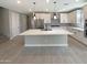 Modern kitchen featuring a large island, white cabinets, stainless steel appliances, and stylish backsplash at 11663 W Luxton Ln, Avondale, AZ 85323