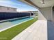 Inviting pool surrounded by artificial turf and a tiled patio area at 11663 W Luxton Ln, Avondale, AZ 85323