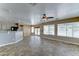 Bright, open-plan living room with tiled floors and a ceiling fan at 15454 W Evans Dr, Surprise, AZ 85379