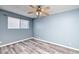 Simple bedroom space features stylish flooring, ample natural light, and overhead ceiling fan at 1556 E Dover Cir, Mesa, AZ 85203