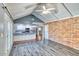 Bright living room featuring brick accent wall, vaulted ceilings, and an open flow to the kitchen at 1556 E Dover Cir, Mesa, AZ 85203
