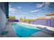 Sparkling swimming pool with a diving board and a vibrant purple fence surround at 1556 E Dover Cir, Mesa, AZ 85203