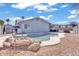Backyard pool area with rock features, an outdoor dining set, and desert landscaping at 15814 N 62Nd Cir, Glendale, AZ 85306