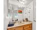 Bathroom featuring a spacious countertop, wooden vanity, and a large mirror at 15814 N 62Nd Cir, Glendale, AZ 85306