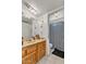Bathroom showcasing a wooden vanity, spacious countertop, and a charming checkered shower curtain at 15814 N 62Nd Cir, Glendale, AZ 85306