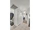 Bright hallway leading to a bathroom and bedroom, featuring tiled flooring and white doors at 15814 N 62Nd Cir, Glendale, AZ 85306
