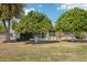 Lush backyard with mature trees and a screened-in patio provides privacy and shade at 17885 N 99Th Dr, Sun City, AZ 85373