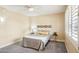 Inviting bedroom with a ceiling fan, large window, and plush carpeting exudes comfort and relaxation at 17885 N 99Th Dr, Sun City, AZ 85373