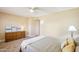 Inviting bedroom with a ceiling fan, large window, and plush carpeting exudes comfort and relaxation at 17885 N 99Th Dr, Sun City, AZ 85373
