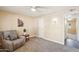 Cozy bedroom with plush carpet and comfortable chair at 17885 N 99Th Dr, Sun City, AZ 85373