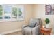 Relaxing bedroom with a plush chair, a small side table, and bright window at 17885 N 99Th Dr, Sun City, AZ 85373