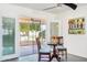 Bright breakfast nook with a table set, views of the enclosed patio, and direct access to the outdoors at 17885 N 99Th Dr, Sun City, AZ 85373