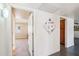 Bright hallway leads to a bedroom featuring neutral tones and natural light from the window at 17885 N 99Th Dr, Sun City, AZ 85373