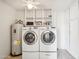 Functional laundry room featuring a stacked washer and dryer, storage cabinets, and a water heater at 17885 N 99Th Dr, Sun City, AZ 85373