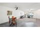 Spacious living room with white walls, ceiling fans, a breakfast nook, and a combination of carpet and tile flooring at 17885 N 99Th Dr, Sun City, AZ 85373