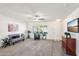 Bright living room with neutral carpet, ceiling fan, white walls, and a combination of carpet and tile flooring at 17885 N 99Th Dr, Sun City, AZ 85373