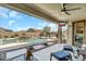 Relax on the covered back patio with a ceiling fan, outdoor tv and beautiful pool view at 18120 W Cassia Way, Goodyear, AZ 85338