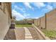 This is a long backyard with desert landscaping and a patch of artificial turf at 18120 W Cassia Way, Goodyear, AZ 85338
