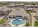 Aerial view of a backyard with a freeform pool, spa, patio, and lounge area, surrounded by desert landscaping and mountain views at 18120 W Cassia Way, Goodyear, AZ 85338