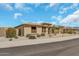 A front exterior of a desert home featuring desert landscaping, a three-car garage, and a well manicured yard at 18120 W Cassia Way, Goodyear, AZ 85338