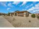 A front exterior shot of a desert home with desert landscaping and a three-car garage at 18120 W Cassia Way, Goodyear, AZ 85338
