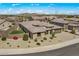A high angle shot of a desert home with desert landscaping, a three-car garage, and green grass at 18120 W Cassia Way, Goodyear, AZ 85338